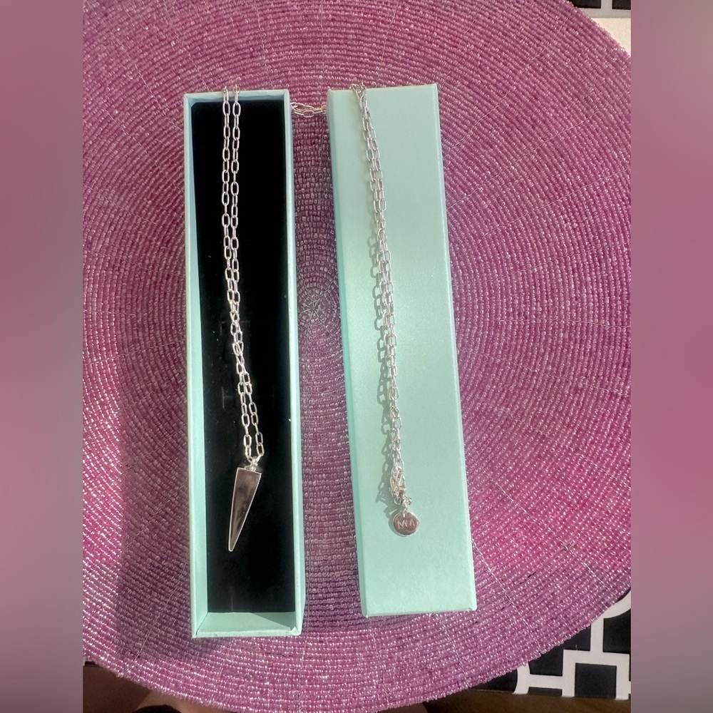Silver tone pendulum pendant necklace on 36 inch open ring chain.